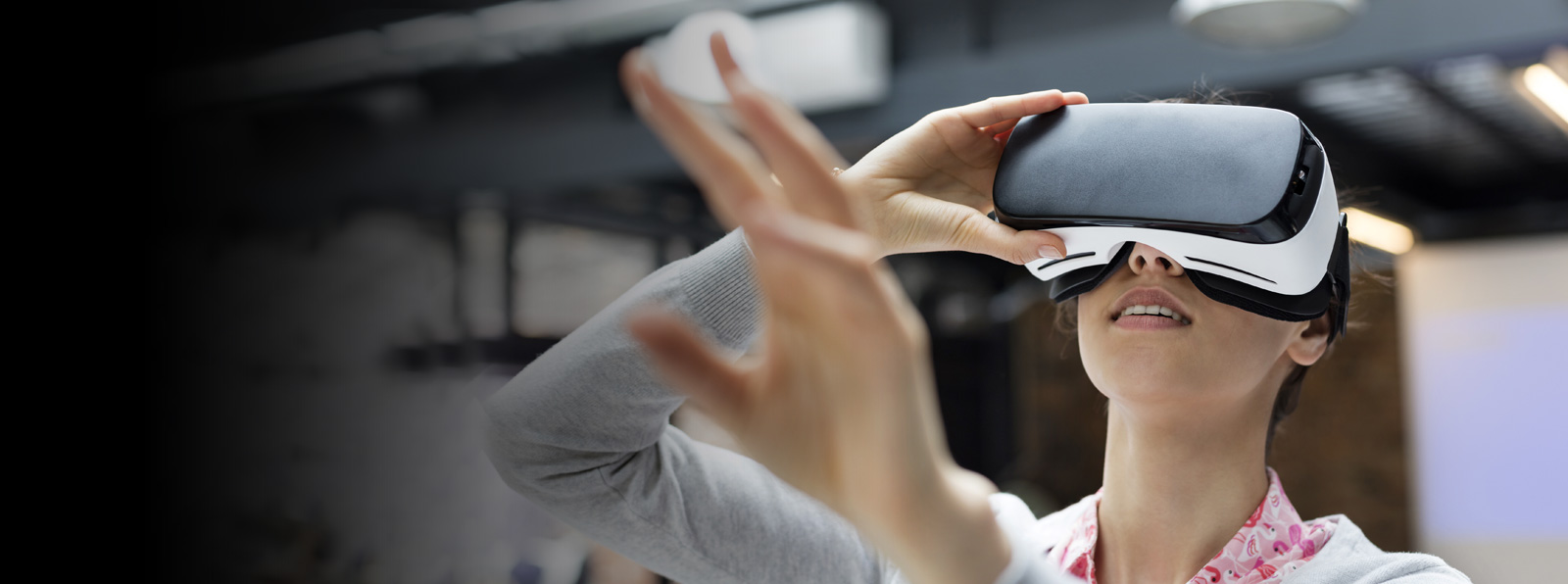 A woman wearing VR goggles looks up