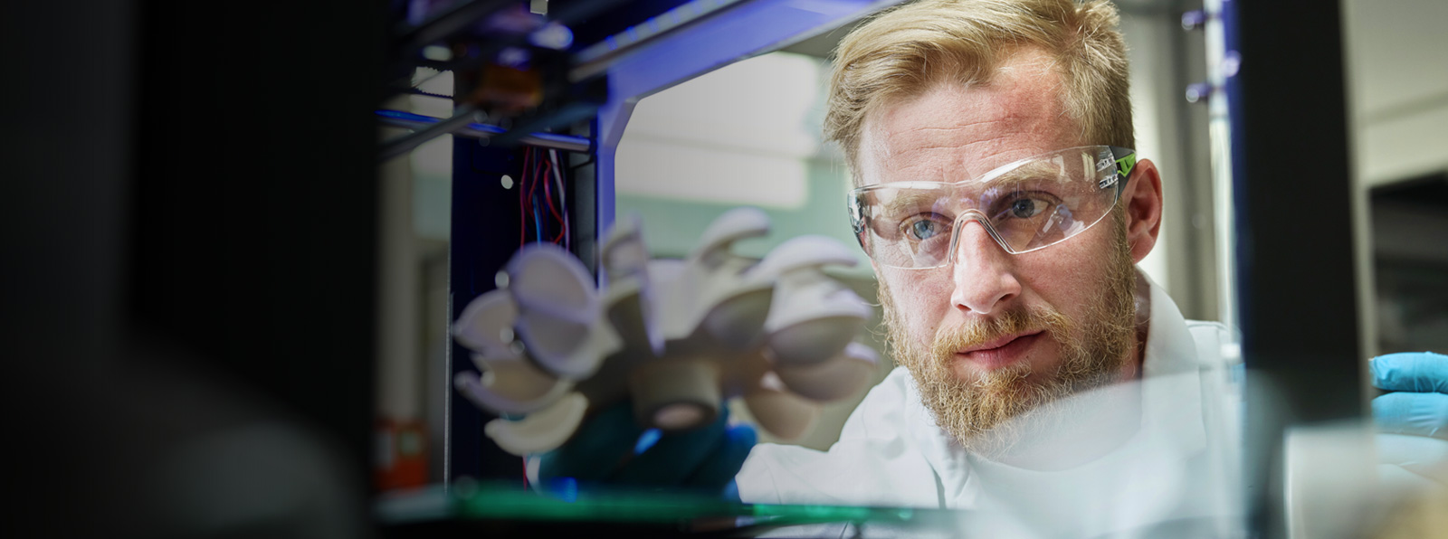 Man wearing safety glasses looking at centrifuge