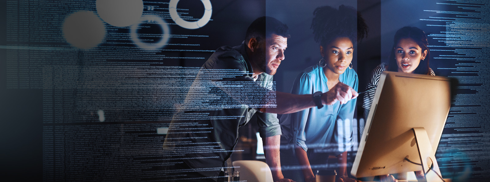 Three people look on at a computer monitor together