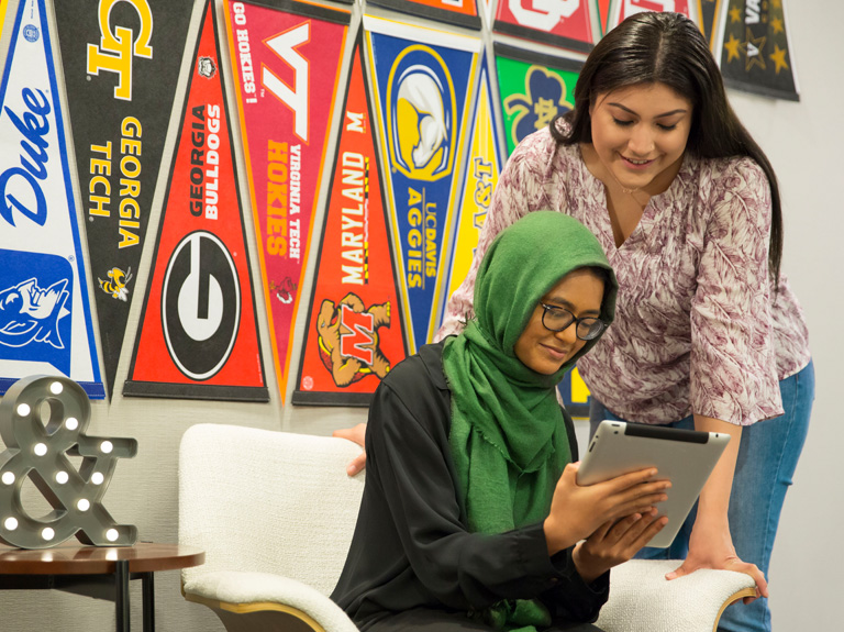 Two women look on at a tablet together