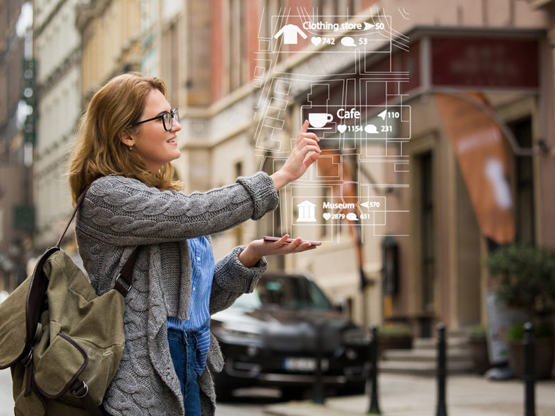 Woman with her phone projecting a map in front of her.