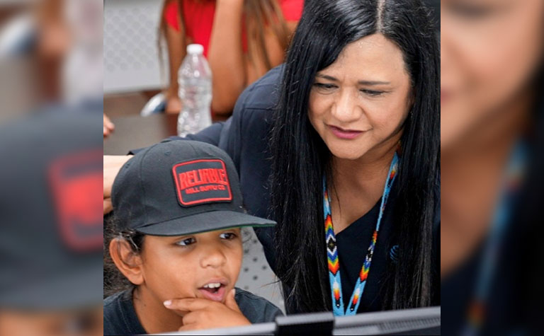 Rachel Salinas helps a young resident of the Pomo Nation reservation navigate online and The Achievery, AT&T’s free digital learning platform for K-12 students.